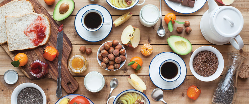 A table covered in nuts, fruit, grains, and cups of coffee