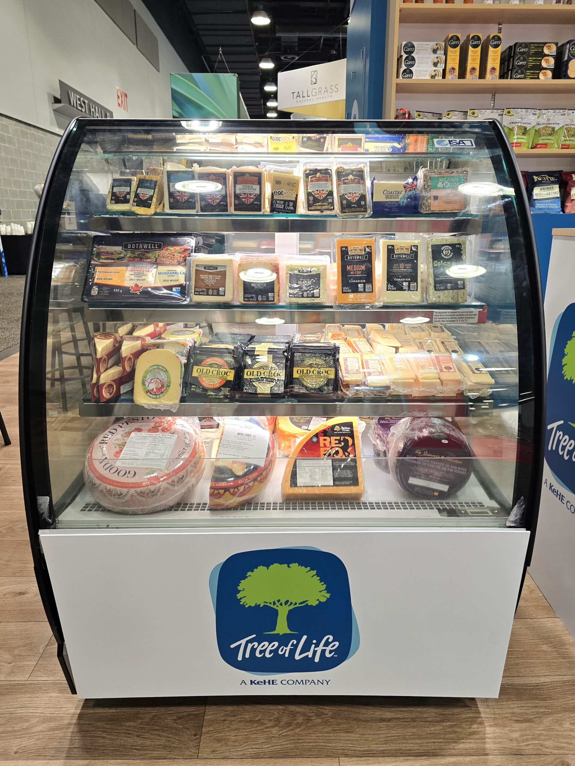 Image of a refrigerator filled with cheese at a trade show.