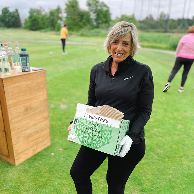 A Tree of Life employee with a box of Fever-Tree at a golf tournament