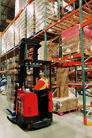 A worker driving a forklift in a warehouse